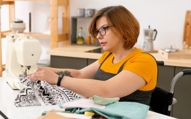 Woman sitting down at sewing machine