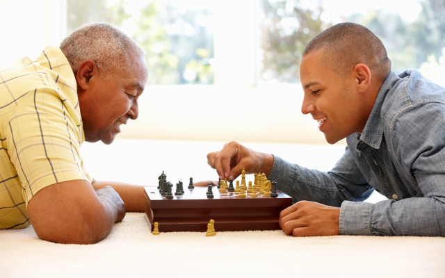 Elderly man and young man playing chess